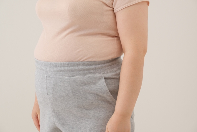 お腹から腰まわりに脂肪がついた女性のイメージ