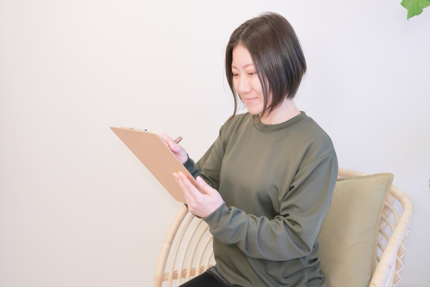 サロンの椅子に座って問診票に記入するお客様
